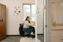 Student working at a desk in a residence room in DeVries Centre