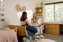 Two students talking in a Robson Hall residence room.