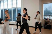 Students participating together in a group fitness class in a mirrored studio.