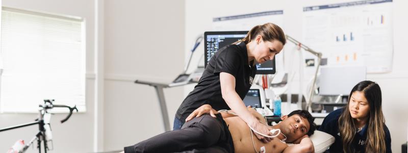 Professor teaching student with live patient on table