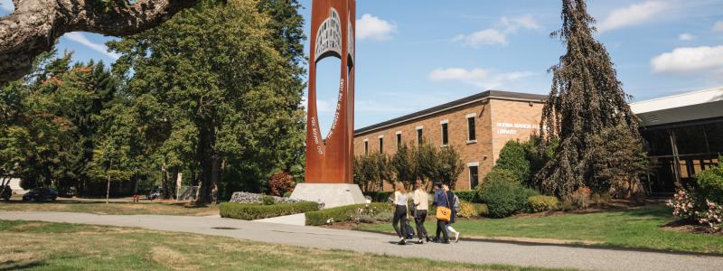 students walking outside library and bell tower