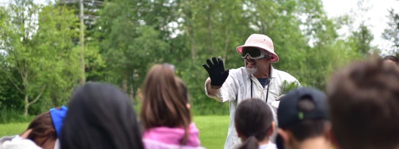 person teaching kids about science outside