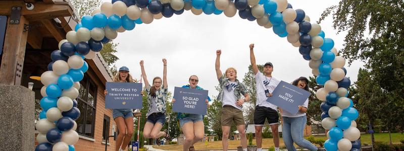 students welcoming under a balloon arch