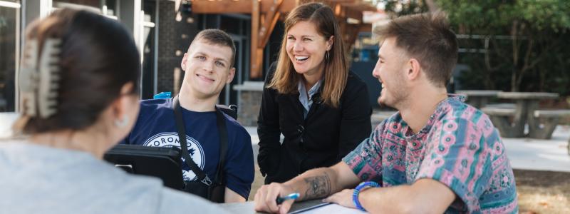 people siting outside at table smiling