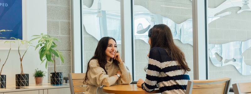 two people meeting at table and smiling