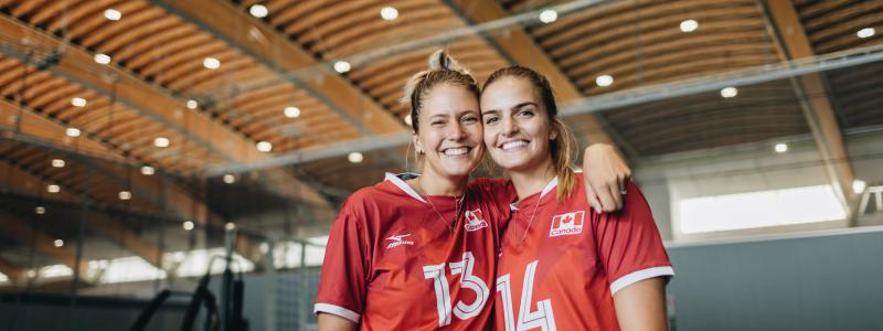 two women in gym smiling with arms around each others shoulders
