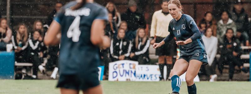 women playing soccer in the rain