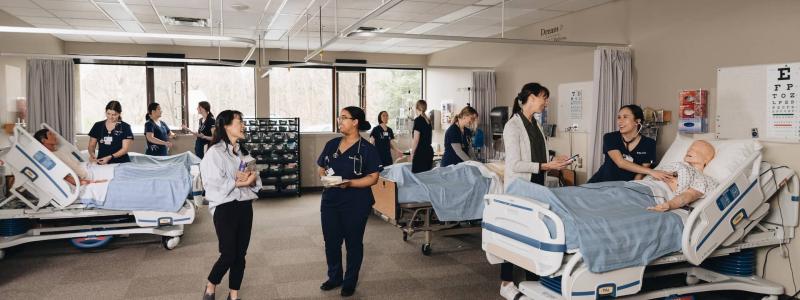 nursing students working with instructors in lab