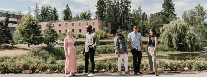 students and staff standing outside by pond