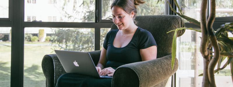 student using a laptop and smiling