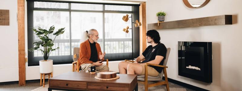 two people sitting in room talking