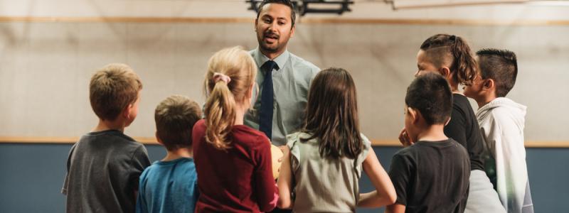 teacher talking with students in gym