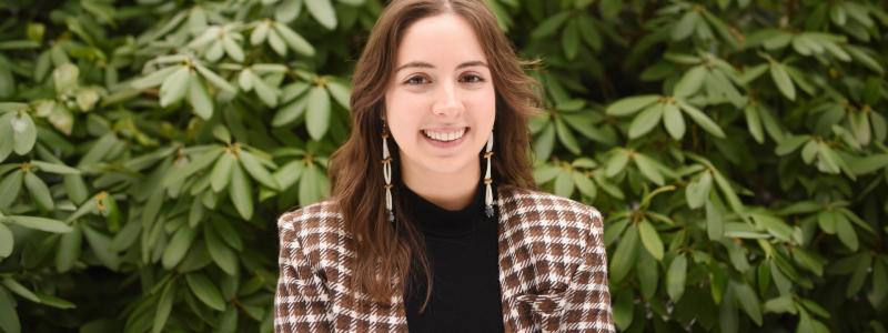 Madison Stenner standing in front of green plants