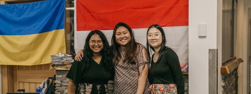 group of students standing in front of flags