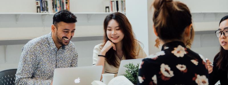 students smiling and working at a table