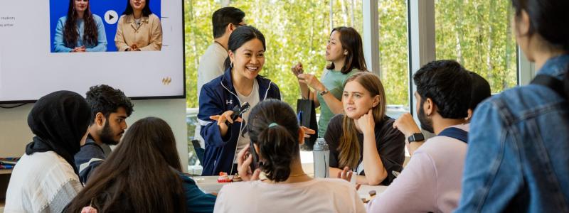 woman talking to a table of students in the Global Lounge