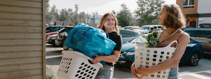 students holding baskets of belongings to move in to dorms