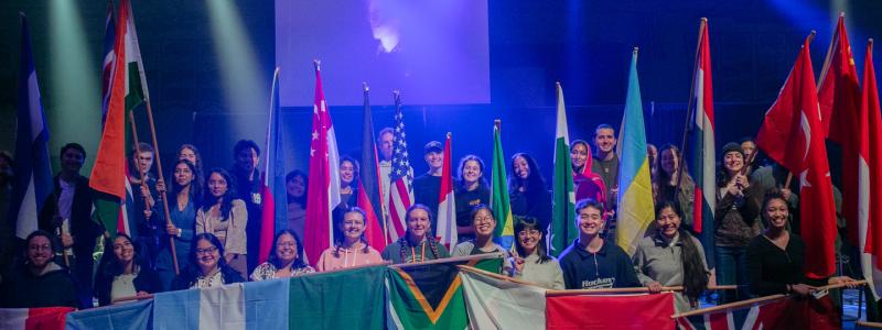 students holding flags from different countries gathered together
