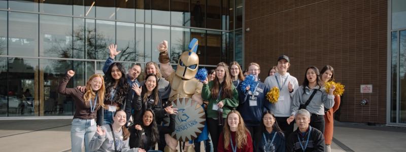 group of people and Sparty posing in front of Kuhn Centre
