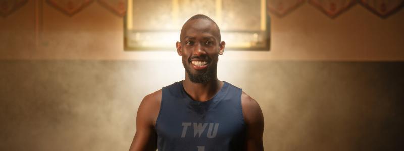 David standing with light behind him in a basketball court