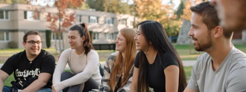 Group of students sitting on the Douglas lawn.