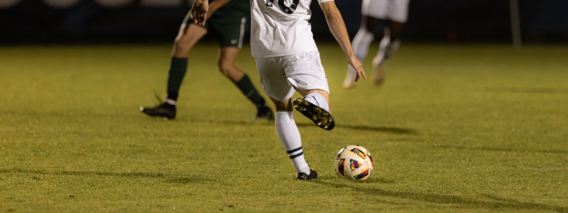 A picture of a man kicking a soccer ball.