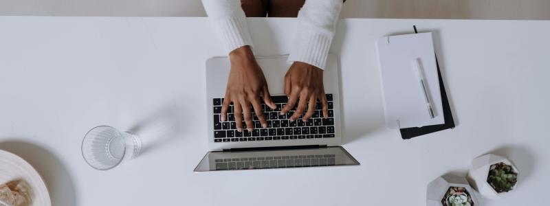 Person typing on a laptop keyboard.