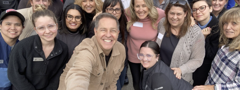 Group of smiling adults posing outdoors.
