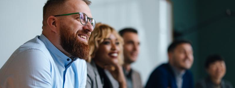 Smiling group of diverse professionals in a meeting room.