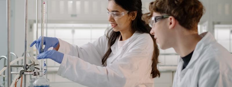 Two scientists in lab coats conducting an experiment.