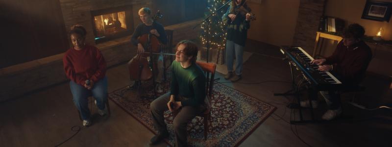 people playing music in front of Christmas decorations