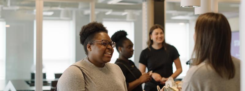 People smiling and talking in an office building