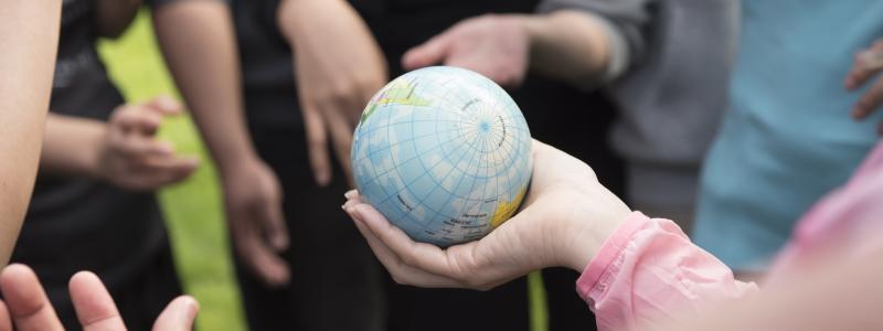hands holding a ball that looks like earth