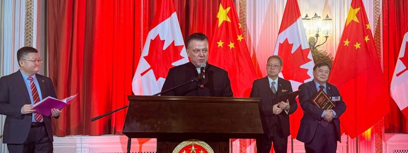 Man at podium addressing audience for award ceremony.