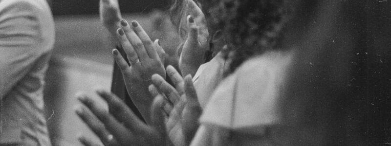 Black and white photograph of a group of people praying in worship