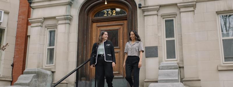 two women walking down the steps of the Laurentian Leadership Centre in business attire