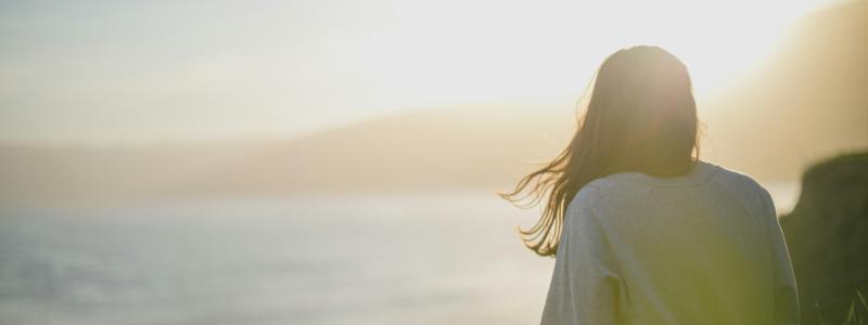Woman watching a sunrise over an ocean