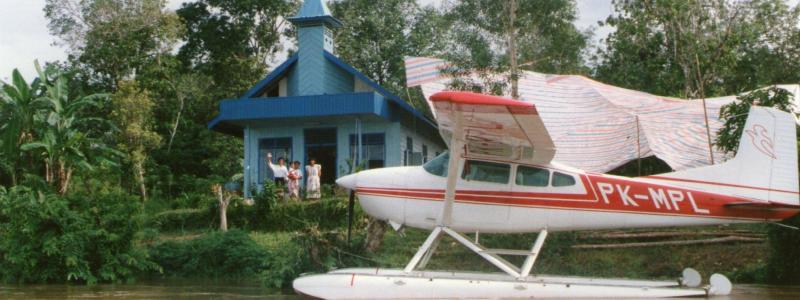 pontoon plane on the water in front of a church building