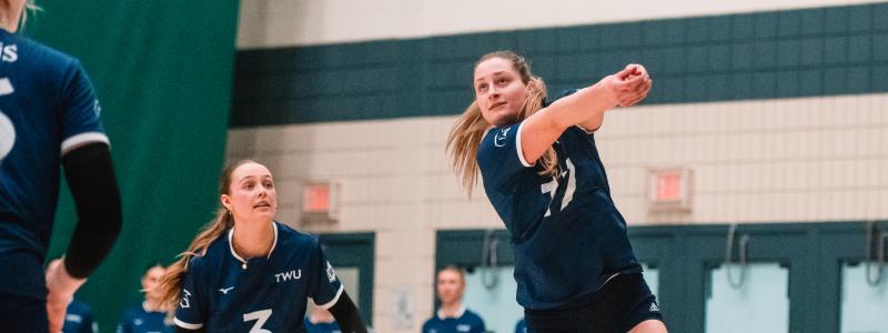 Women in blue jersey playing volleyball