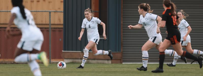 group of women wearing white jersey and playing in the field