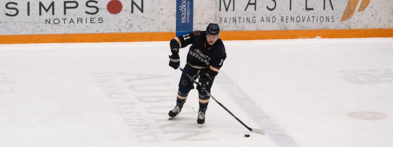 TWU student playing hockey in men's hockey game.