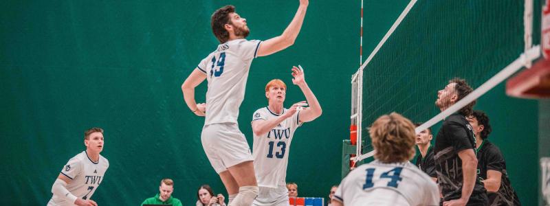 Men in white jersey playing volleyball in a court