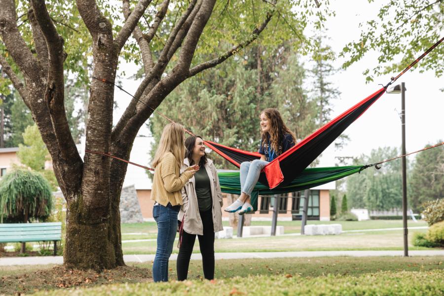 Students on Langnley campus in hammocks talking.