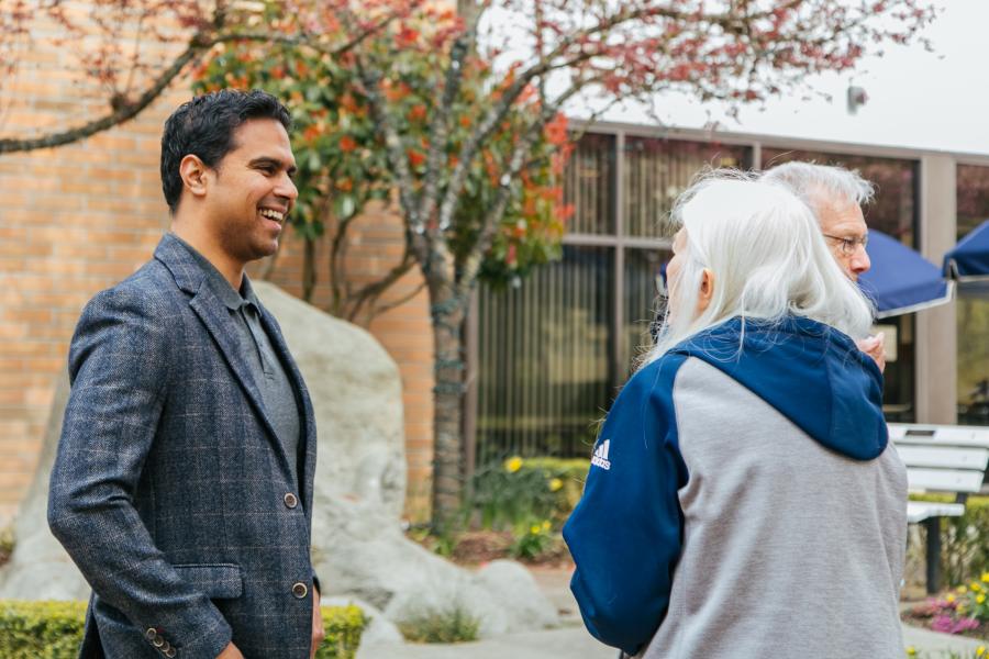 man talking with older women in front of Reimer