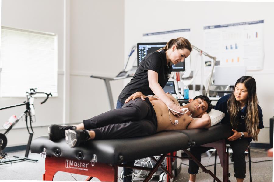 Professor teaching student with live patient on table