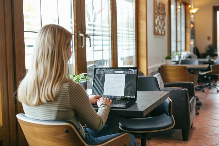 Female Student working on laptop in Trinity House