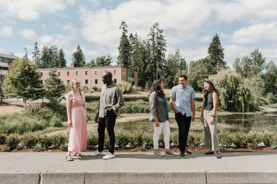 Five students standing near the lake 