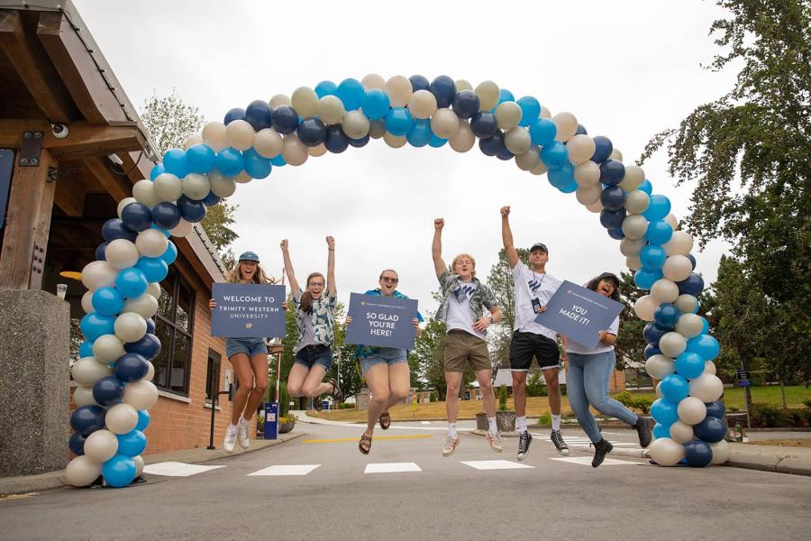students welcoming under a balloon arch