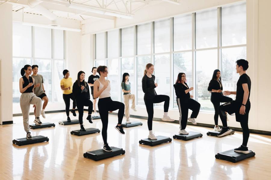 students in a group exercise class inside