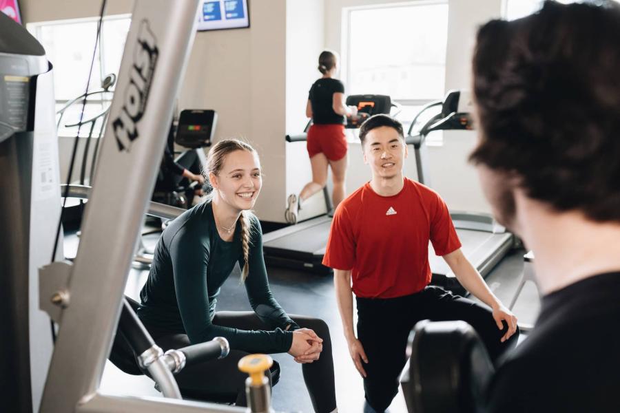 students with student trainer in gym